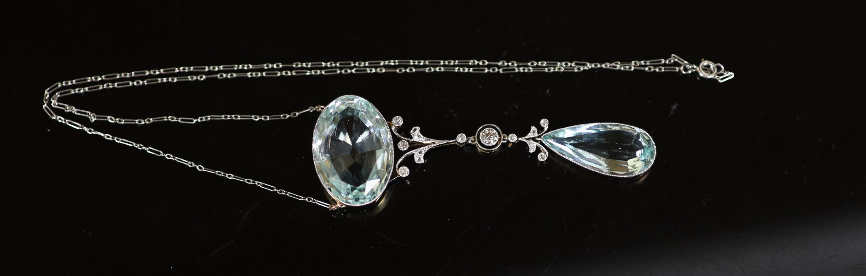 An early 20th century gold and platinum, millegrain set diamond and two stone aquamarine set drop pendant necklace, with a fine link platinum chain